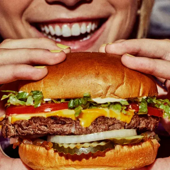 woman holding a cheeseburger