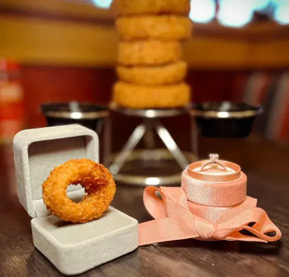 Onion ring in ring box sitting next to diamond ring