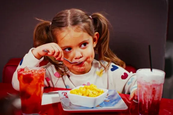 Kiddo enjoying mac and cheese and freckled lemonade