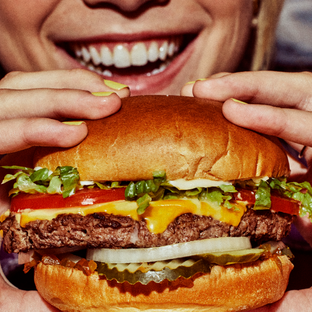 woman holding a cheeseburger